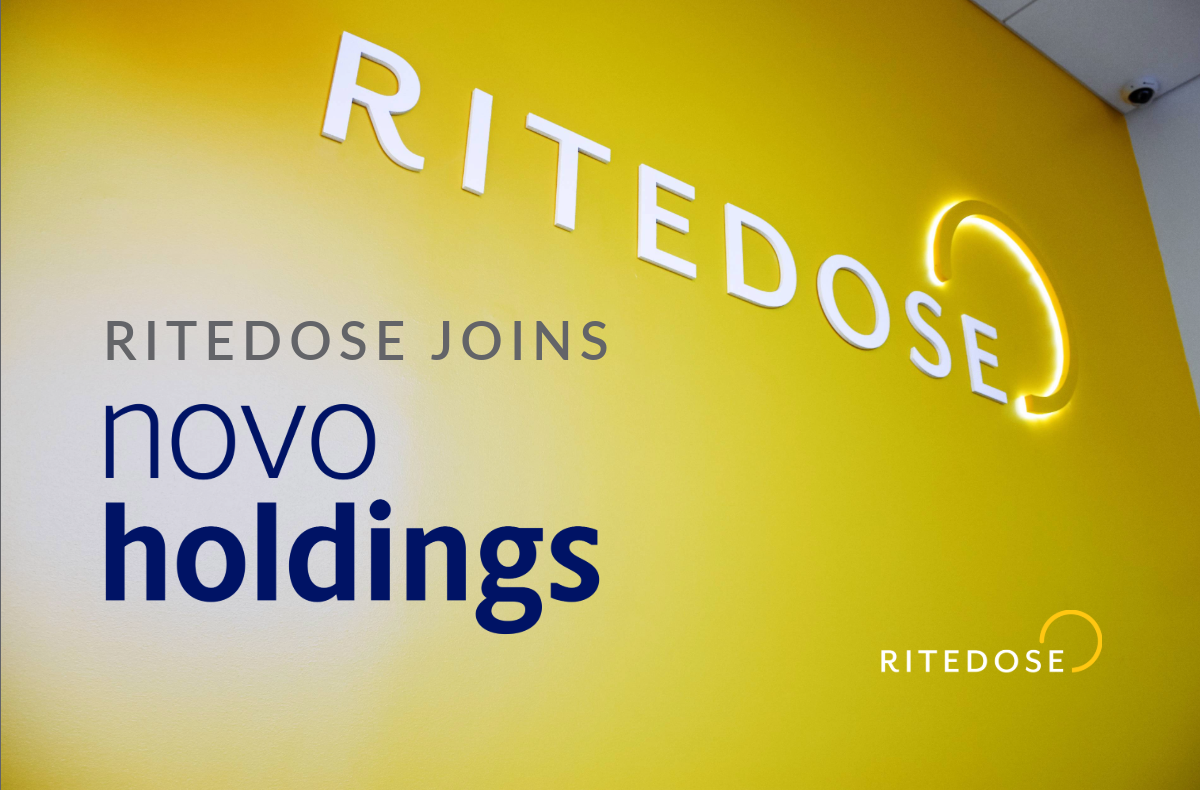 angled view of a yellow wall with white letterforms and a backlit logo mark with text overlay: Ritedose joins Novo Holdings