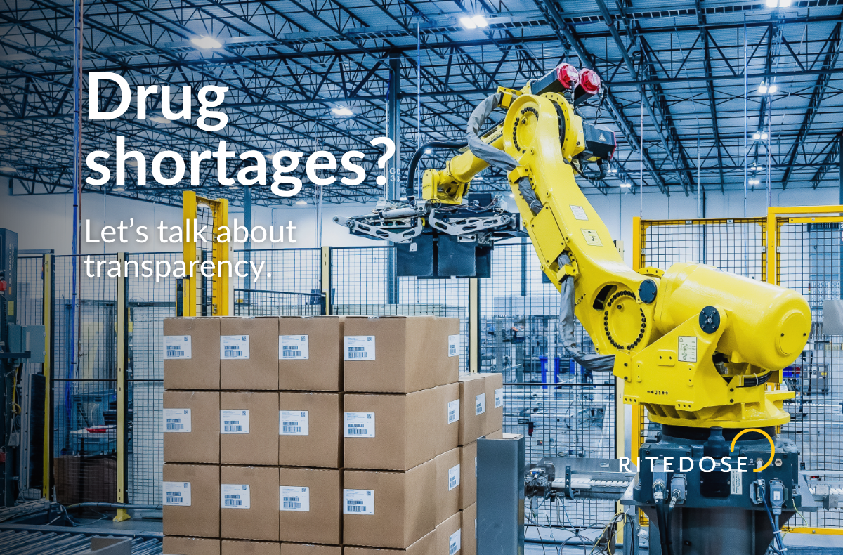 Automated pharmaceutical warehouse with a yellow robotic arm stacking cardboard boxes, illustrating Ritedose’s focus on transparency, efficiency, and solutions for drug shortages.